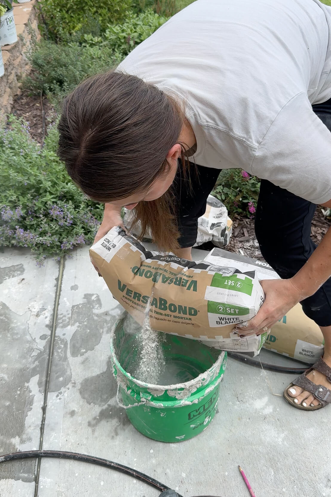 Mixing mortar to cover up and update an old rock wall.